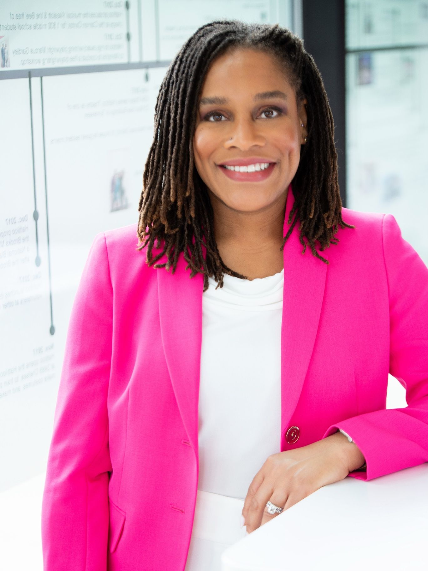 Zakiya Woods smiling in a bright pink blazer